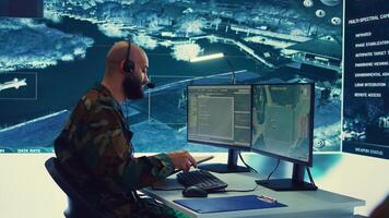 Military operator transmitting gps coordinates of hostile ships to national guard, providing real time data from surveillance CCTV system. Army officer works in power base control center. Camera B. photo