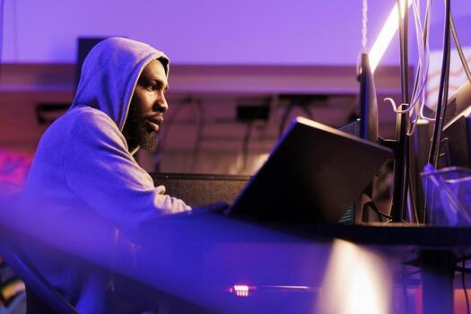 hacker rotura ley mientras codificación ilegal Secuestro de datos para robando intimidad datos. Internet estafador en capucha planificación en línea fraude mientras programación malicioso software en computadora foto