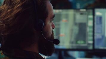 Commander communicating with allied forces and transmitting data from surveillance footage, coordinating joint operations and strategies to accomplish mission. Satellite radar operator. Camera A. photo