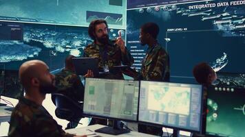 Officers team managing air traffic control for military aircrafts within the operational area, using CCTV radar surveillance. Evaluating and presenting mission plans to their crew. Camera B. photo
