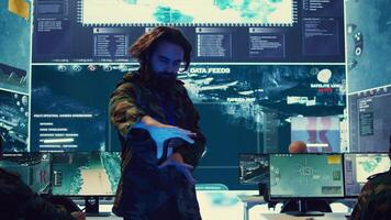 Command sergeant major employs high tech holograms to examine real time data for a mission, working on ways to protect the national coast line. Creating an attack plan. Camera B. photo