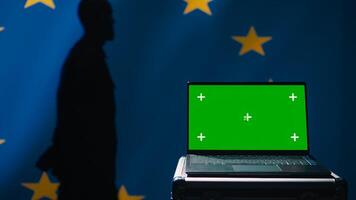 European Union agency using green screen laptop to protect against mass propaganda affecting elections. EU security service engaging in psychological operations using mockup device, close up, camera B photo