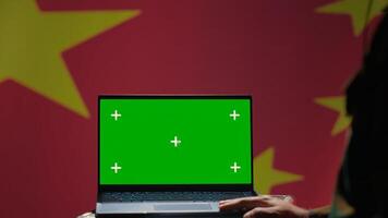 Chinese soldier using military tech on green screen laptop to identify threats from enemies. Army personnel using software on mockup notebook to communicate information to war front lines, camera A photo