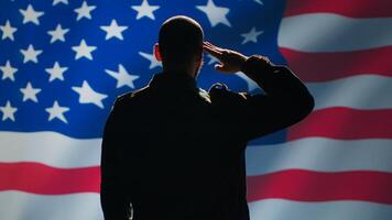 American soldier doing saluting hand gesture towards USA flag in command center, showing respect. Military unit in uniform serving in United States Armed Forces, doing patriotic gesturing, camera A photo