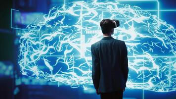 Computer scientist wearing VR headset looking at hologram of artificial intelligence human brain simulation. Indian man interacting with AI visualization showing machine learning algorithms, camera B photo