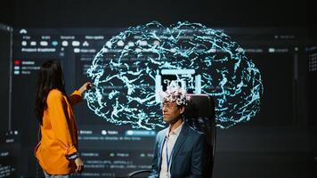 Company CEO using summit as platform to launch latest AI EEG headset product. Neuroscientist doing demonstration at forum in front of business leaders interested in artificial intelligence, camera B photo