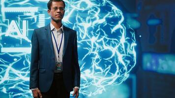 Upbeat engineer in startup doing advancements in AI field. Portrait of happy man standing with arms crossed in front of cutting edge display featuring AI and neural network graphics, camera A photo