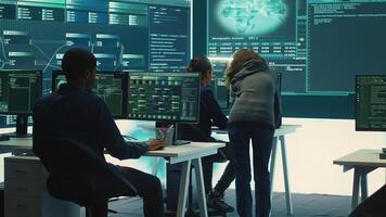 Governmental hackers team securing computer systems from cyber threats, working together in agency control room. Emphasizing encryption, online security and espionage against cyber attacks. Camera A. photo