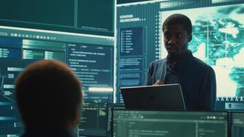 Governmental hackers performing a cyber attack simulation after studying the national database servers. Experts working on IT security, data breach prevention against ransomware. Camera A. photo