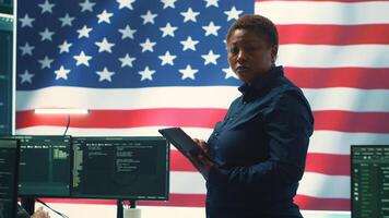 Cybersecurity specialists in a high tech office with the American flag, focusing on cyber intelligence and secure network operations. Works on information security and malware detection. Camera A. photo
