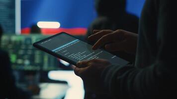 Person uses tablet in governmental cyber security room working under the Russian flag. Making cyber threats, hacking systems to gain unauthorized access, and spreading fake news. Close up. Camera A. photo