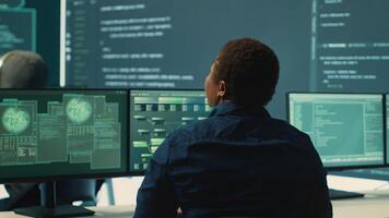 Governmental hackers analyzing big data for cyber threat detection, working at agency desks. Professional expert woman analyzes cyber intelligence and prevention of digital threats. Camera A. photo