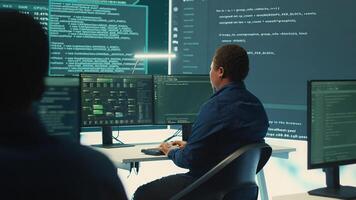 Governmental hackers using advanced software to protect against cyber threats, working in team. Specialists on cyber security, data and network protection unite forces in high tech office. Camera A. photo