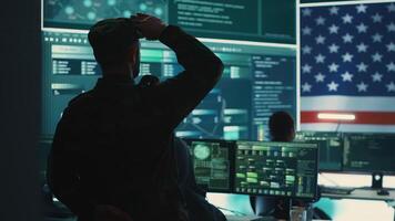 US military man supervising threat detection activity in high tech office, examining top secret data on big screen. Governmental soldiers managing hybrid war, cyber attack prevention. Camera A. photo