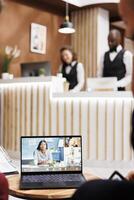 People open videocall meeting in lobby at hotel reception, attending online teleconference to discuss new business improvement strategy. Creating future partnerships between corporations. photo