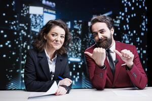 Reporters team presenting daily news and events, addressing latest problems on live midnight talk show. Two media journalists reading headlines in newsroom, work on entertainment segment. photo