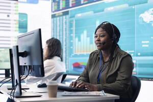 Woman sales manager verifies infographics plan in company coworking space, works on creating business strategies and goals. Employee studying market dynamics and big data at workstation. photo