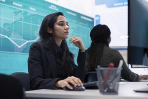 General director reads insight about a new expansion strategy on pc, big screen in enterprise office. Analyst presenting reports and infographics to analyze business activity status. photo