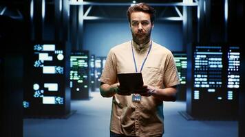 Computer scientist doing yearly checkup to extend data center electronics life span and avoid downtime. Experienced professional monitoring server infrastructure components photo