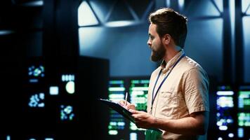 Admin walking in data center supporting AI through high performance computing, hosting specialized storage and networking hardware. Engineer ensuring server room internal hardware functions properly photo