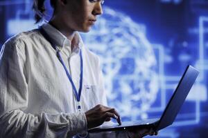 System administrator using laptop to maintenance artificial intelligence neural networks simulating human thought processes in computerized model. Adept professional doing checkup on AI systems photo