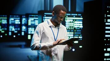 Technician in high tech facility walking through server rigs used for computationally intensive tasks such as molecular modeling or physical simulations. Specialist doing routine equipment maintenance photo
