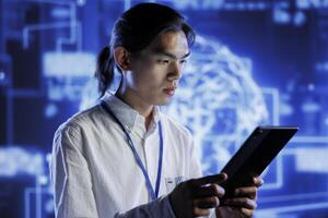 Computer scientist using tablet to maintenance artificial intelligence neural networks simulating human thought processes in computerized model. Tech support doing checkup on AI systems photo