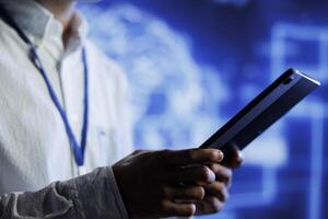 Admin using tablet in server hub to maintenance artificial intelligence neural networks simulating human thought processes. Cloud computing business worker does checkup on AI systems photo
