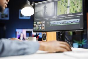 Videographer editing contrast and exposure on montage with color correction program at desk, creating special effects on grading software. Filmmaker editor enhancing clips for post production. photo