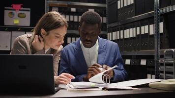 Multiethnic team of private detectives conducts a discreet inquiry, analyzing evidence and investigating records. Caucasian and african american investigators collaborate in office to solve crimes. photo
