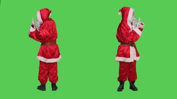 Saint nick pretends to push object aside, wearing december seasonal character red suit and hat. Santa claus character pushing something in rejection, refusing thing over full body greenscreen. photo
