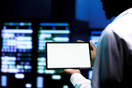 Expert using mock up tablet to examine data center hardware configuration settings . Serviceman inspecting monitoring software event logs to pinpoint root cause of malfunctioning server farm devices photo