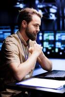 Happy engineer preventing strain on data center infrastructure caused by AI applications driving up power usage. African american expert maintenancing servers doing intense computations photo