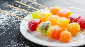 Colorful fruit skewers dusted with powdered sugar photo