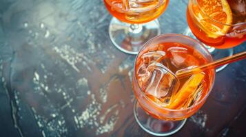 Top view of summer spritz cocktails in glasses with ice, straw and straw on dark solid surface. Top view. Ideal for summer, vacation themes. Good for social media, as banner with copy space photo