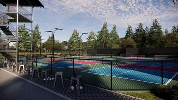 Pickleball courts that are empty, showcasing red, blue, and green floors with white lines, equipped with lighting, fencing, seating, and trees surrounding the courts photo