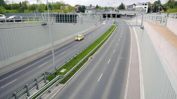 Highway with sparse traffic and overpass. Cars drive on a highway with light traffic, passing under an overpass in an urban environment. video