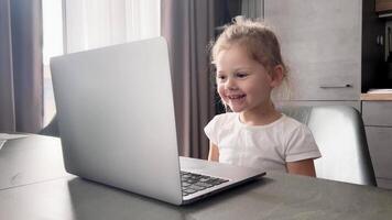 Cute little girl learning with online tutor at home. Child using computer app calling or watching online class lesson. Children education concept. High quality 4k footage video