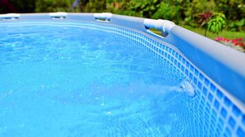 Swimming pool with metal frame for home and garden. Frame swimming pool in the yard. Garden in the background. Summer holiday fun and recreation. photo