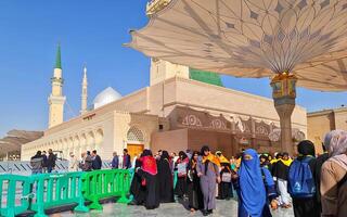 Medina, Saudi Arabia on March 1, 2024. Queues of female Umrah pilgrims from all over the world line up to enter Raudhah or the Tomb of the Prophet Muhammad. Gate 37. Use a registered Tasreh or Nusuk. photo