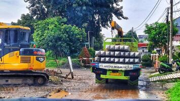 Bekasi, Indonesia on October 7, 2023. A small flat bed truck is transporting a pile of square pile or minipile material.. photo