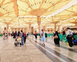 Medina, Saudi Arabia on March 2, 2024. Point of view of an Umrah or Hajj pilgrim walking in the courtyard of the Nabawi Mosque photo