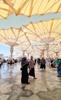 Medina, Saudi Arabia on March 2, 2024. Point of view of an Umrah or Hajj pilgrim walking in the courtyard of the Nabawi Mosque photo