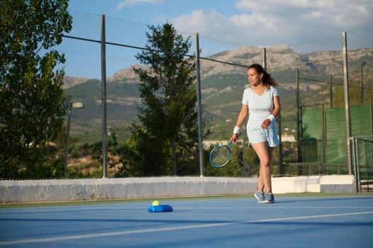 Woman playing tennis in outdoor court on a sunny day photo