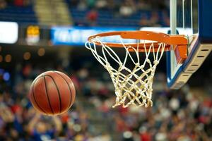 Basketball going through the hoop during a game, capturing the excitement and action of the sport in a dynamic moment. photo