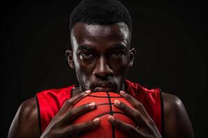 Focused basketball player in red jersey holding a ball. Intense look, ready for game on black background. photo