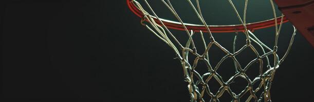 Close-up of a basketball hoop and net in a dimly lit gymnasium, capturing the details of the net and rim. photo