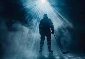 Silhouette of a hockey player standing on ice, illuminated by dramatic lighting, ready for a game in a misty arena. photo
