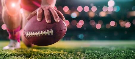 Close-up of a football player's hand ready to snap the ball at the start of a play on a brightly lit field. photo