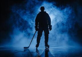 Silhouetted ice hockey player standing on the rink with a smoky blue background, creating a moody and dramatic atmosphere. photo
